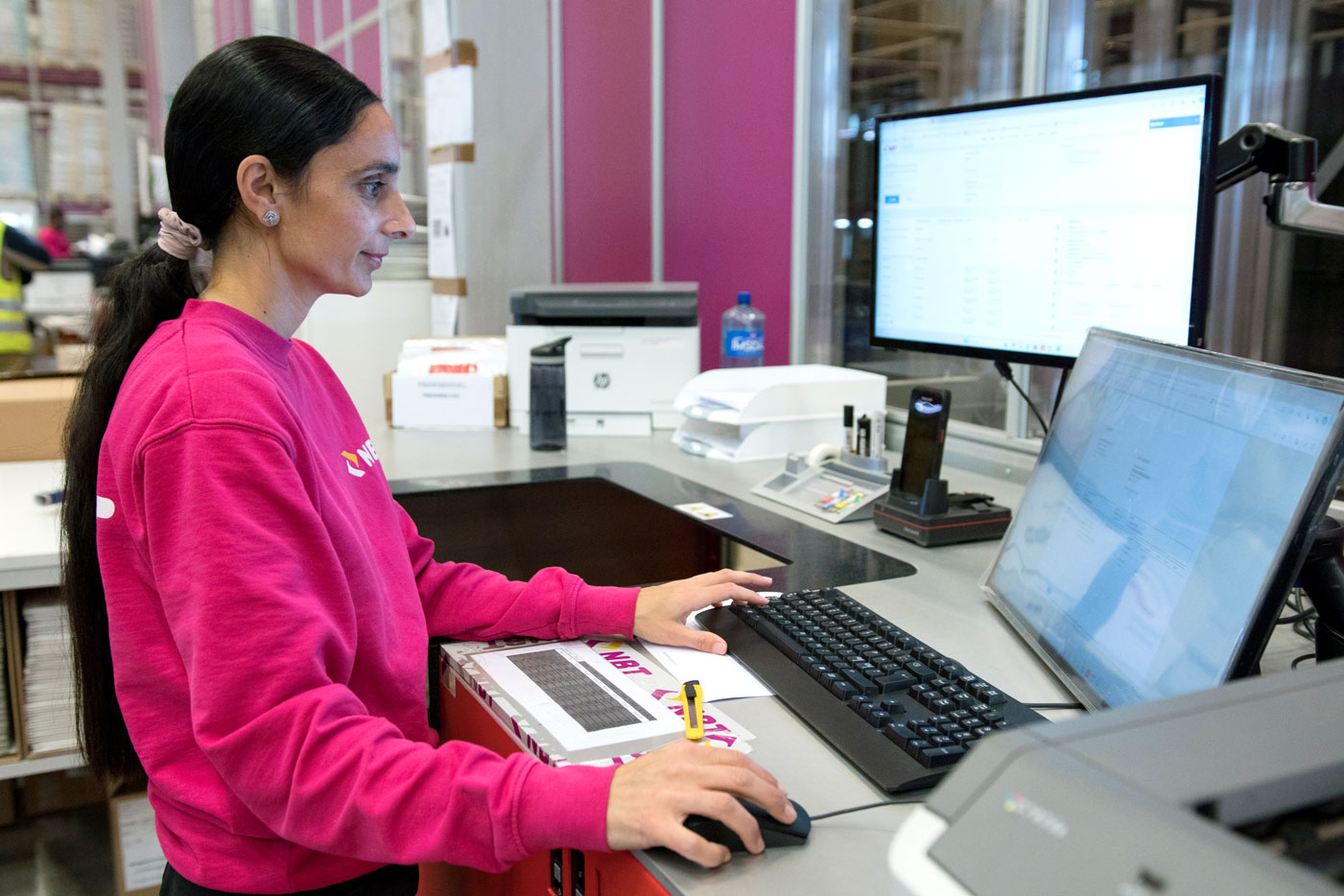 Bilde av en lagermedarbeider som jobber i et Warehouse Management System på PC.